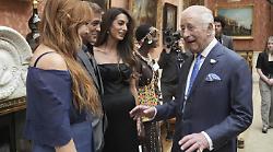 Re Carlo e i Clooney a Buckingham Palace: una risata in salotto, ma il motivo non è mondano