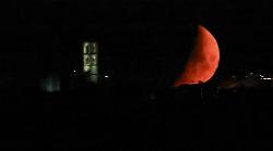 Luna rossa nel cielo dell'Umbria, a Perugia sembra incastonarsi nello skyline della città
