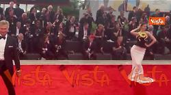 Venezia 82, una modella sfila sul red carpet con un abito decorato da un serpente dorato
