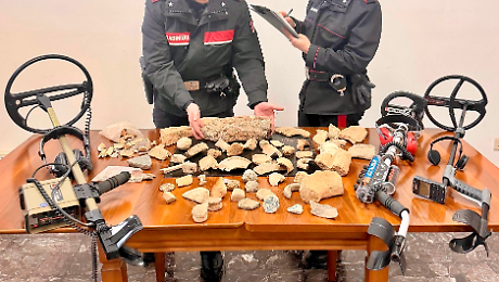 Va col metal detector a caccia clandestina di reperti archeologici e se li porta a casa: sequestrate monete, statuette e medaglie