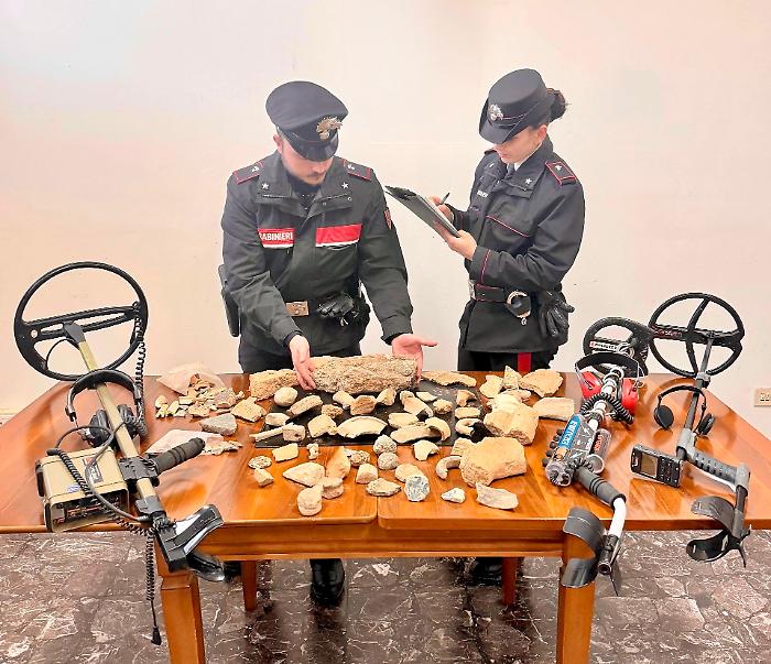 Va col metal detector a caccia clandestina di reperti archeologici e se li porta a casa: sequestrate monete, statuette e medaglie