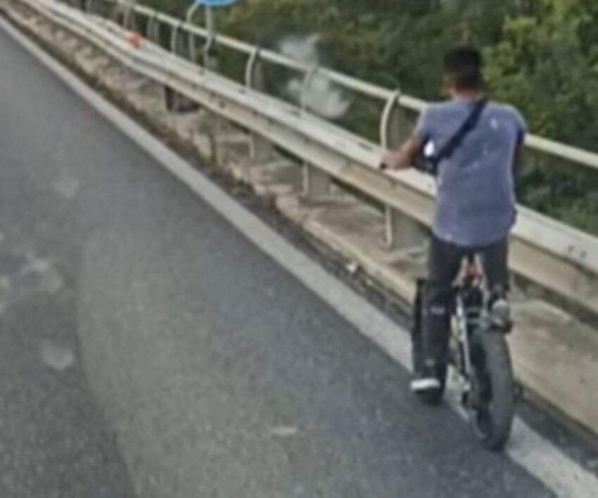 uomo in bici in autostrada